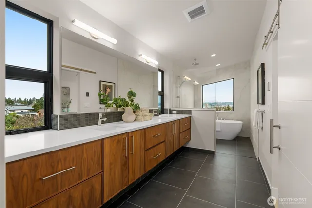 a large bathroom with a double vanity sink a large mirror and a shower