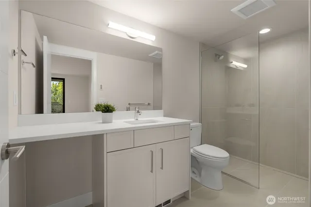 a bathroom with a granite countertop toilet sink and mirror