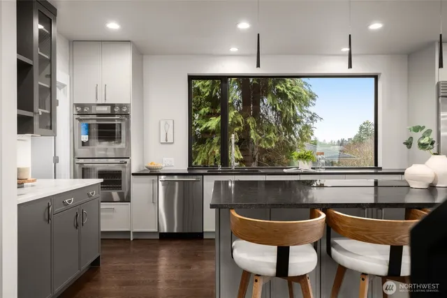 a kitchen with stainless steel appliances granite countertop a stove a sink a microwave a dining table and chairs