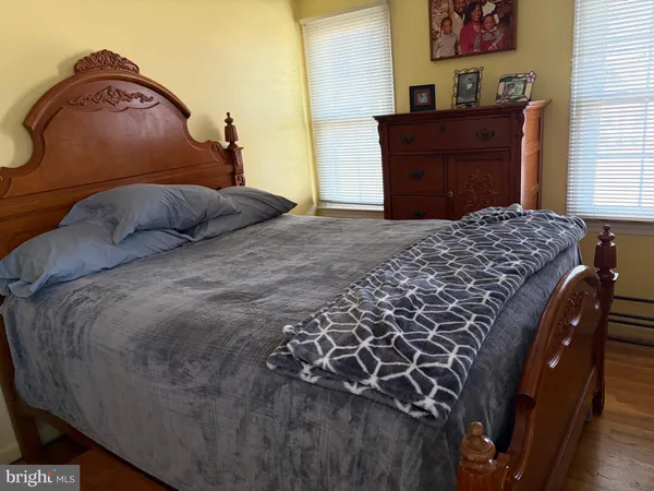 a bed sitting in a bedroom next to a window and dresser