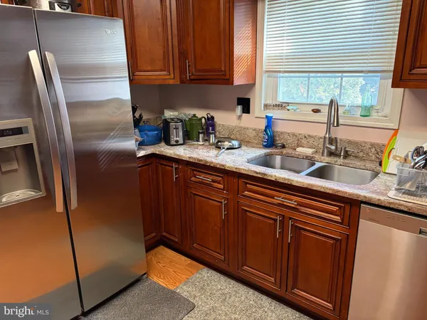 a kitchen with stainless steel appliances granite countertop a refrigerator sink and cabinets