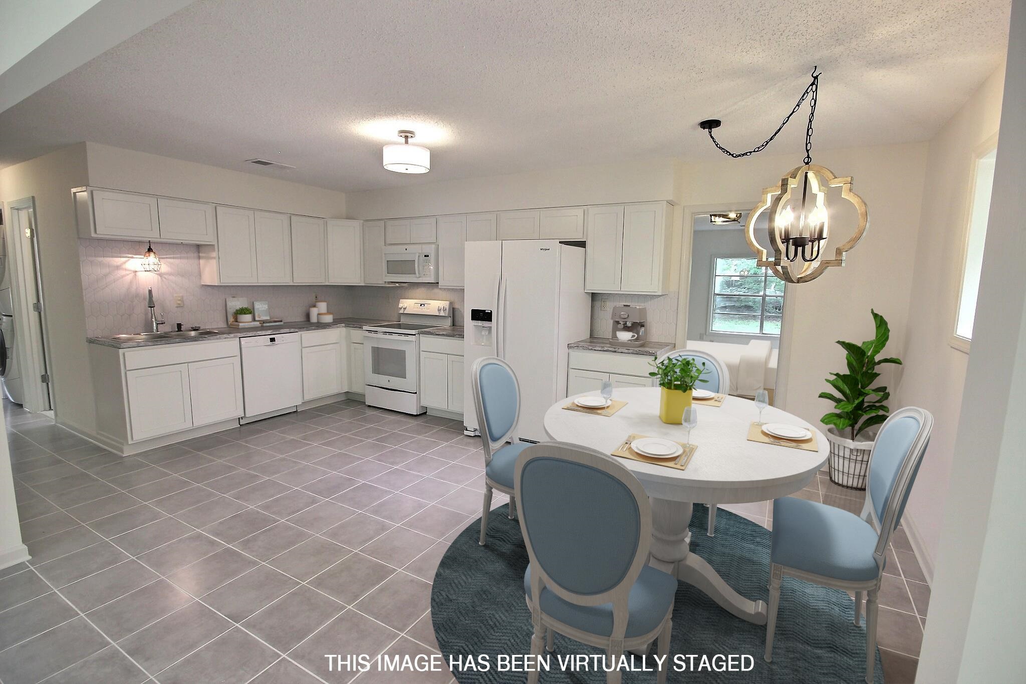 943 Poplar Leaf Road Collierville, TN 38017 - Photo 2 of 17 a kitchen with stainless steel appliances granite countertop a sink a stove a dining table and chairs