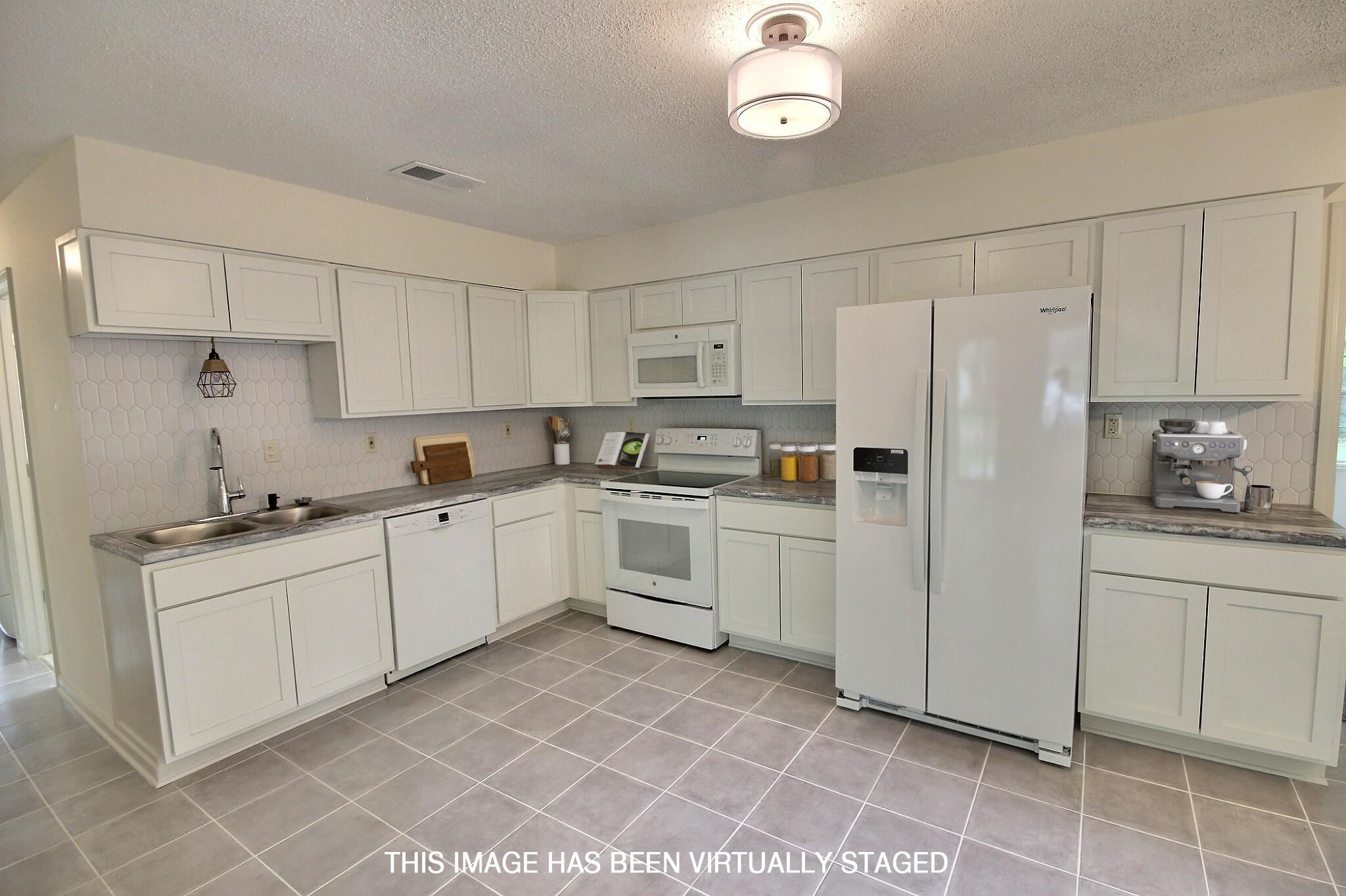 943 Poplar Leaf Road Collierville, TN 38017 - Photo 8 of 17 a kitchen with white cabinets and white appliances