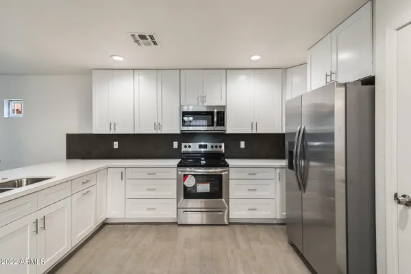 a kitchen with stainless steel appliances granite countertop a refrigerator and a stove