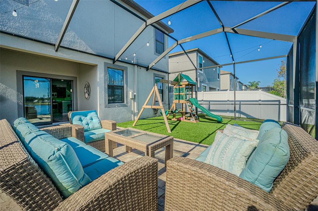 1762 Hadden Hall Place Trinity, FL 34655 - Photo 13 of 39 a view of a patio with couches table and chairs under an umbrella