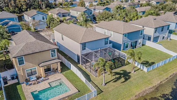 an aerial view of residential houses with outdoor space and swimming pool