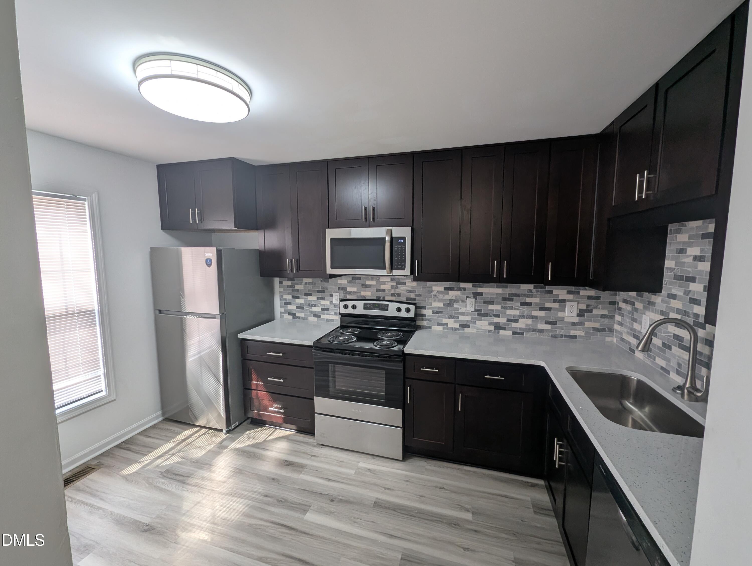1005 Shades Place Raleigh, NC 27601 - Photo 5 of 18 a kitchen with a sink stove and refrigerator