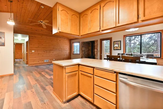 a view of a kitchen with stainless steel appliances granite countertop a sink and cabinets