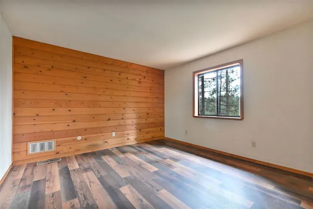 a view of small space with wooden floor and a window
