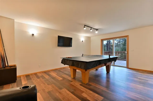 a living room with furniture pool table and a flat screen tv