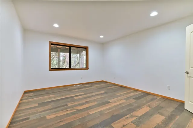 a view of empty room with wooden floor