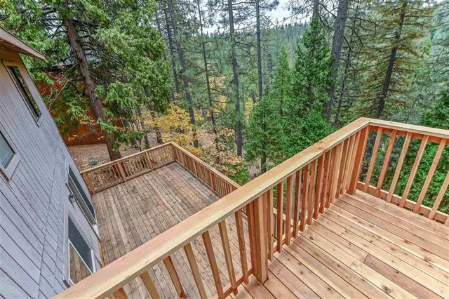 a view of a small house with floor to ceiling window and wooden fence