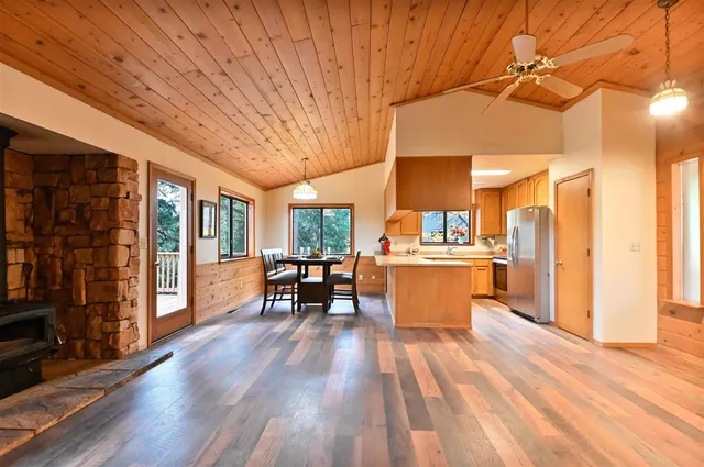a kitchen with stainless steel appliances wooden floor and dining table chairs