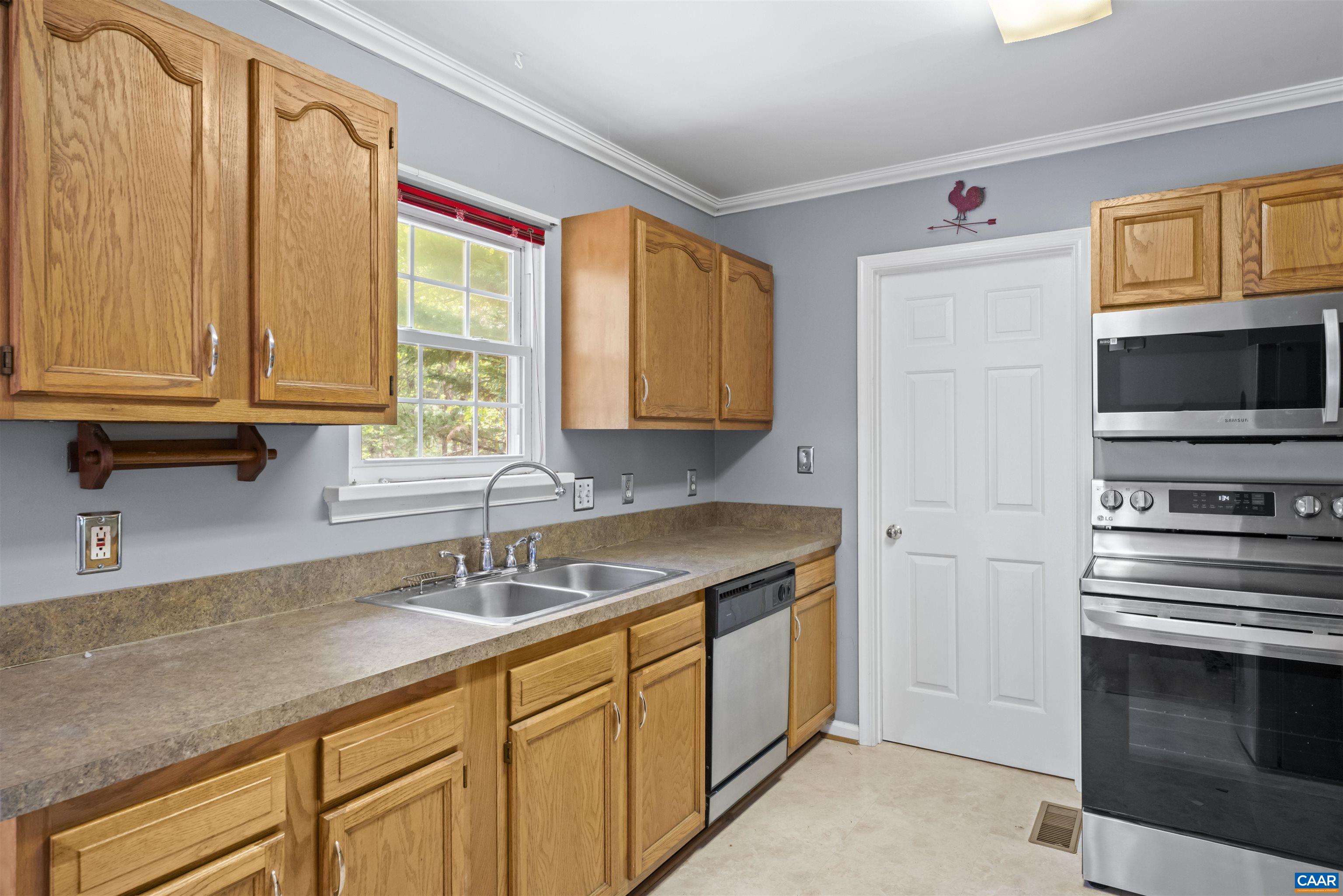 751 Jonquil Road Ruckersville, VA 22968 - Photo 17 of 35 a kitchen with stainless steel appliances granite countertop a sink stove and microwave