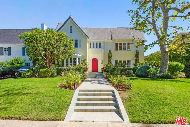a front view of a house with a yard and fountain