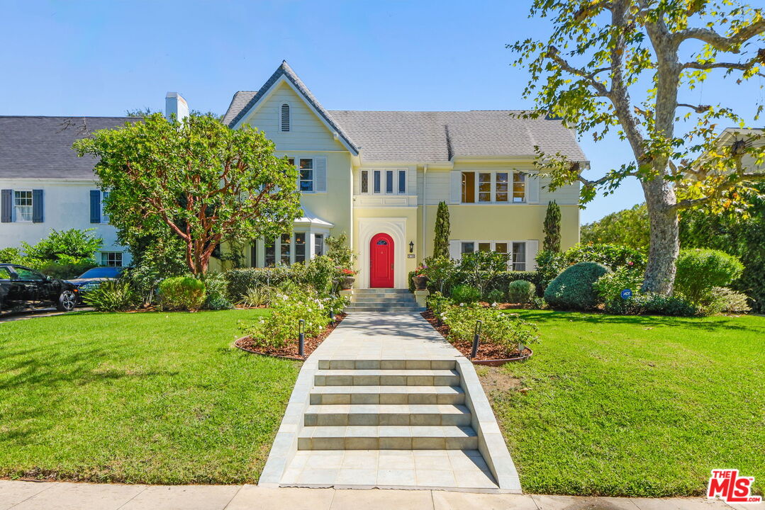 a front view of a house with a yard and fountain