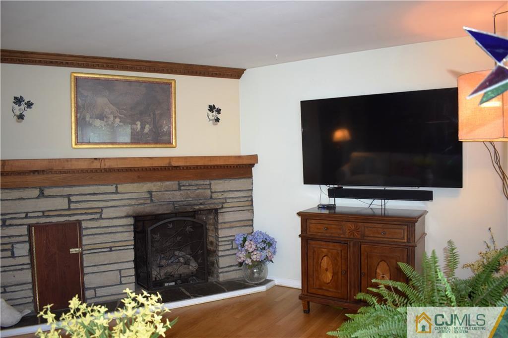 275 Friendship Road Cranbury, NJ 08512 - Photo 3 of 23 a living room with a fireplace and a flat screen tv