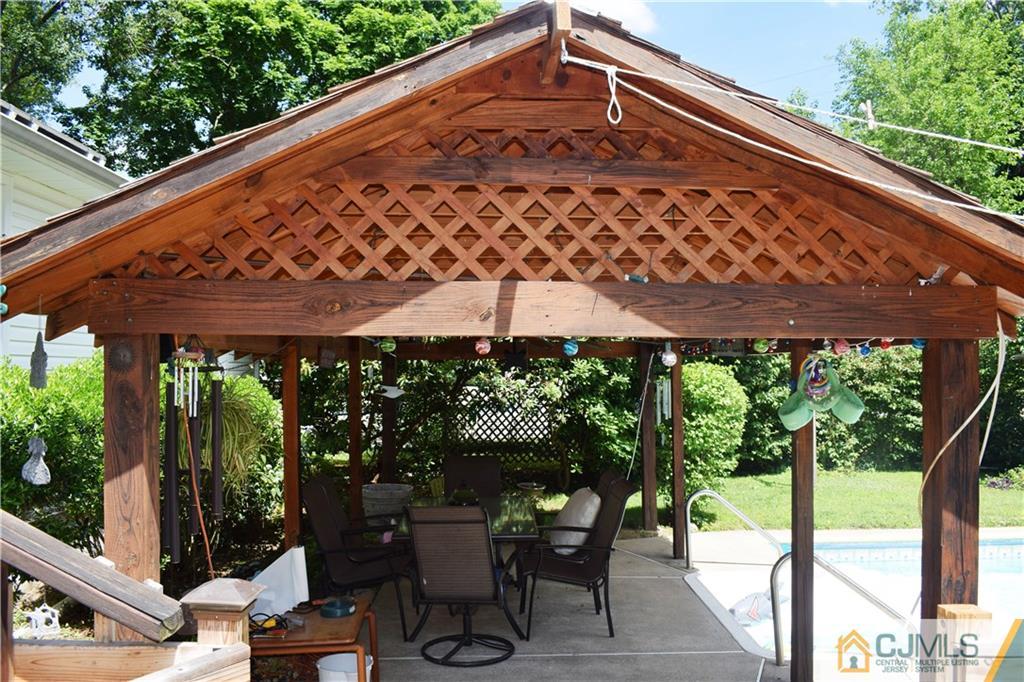 275 Friendship Road Cranbury, NJ 08512 - Photo 22 of 23 a view of a patio with table and chairs under an umbrella