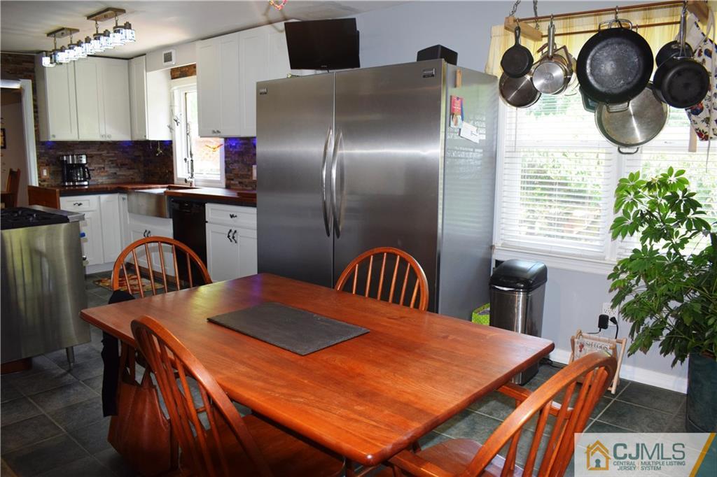 275 Friendship Road Cranbury, NJ 08512 - Photo 7 of 23 a kitchen with stainless steel appliances granite countertop a stove a refrigerator a dining table and chairs with wooden floor