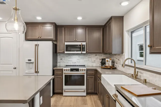 a kitchen with stainless steel appliances a sink stove and refrigerator