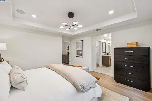 a spacious bedroom with a bed and a dresser