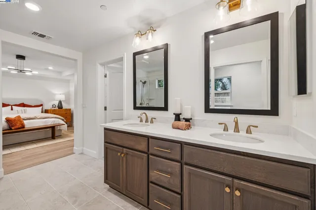 a en suite bathroom with double vanity sinks and a mirror