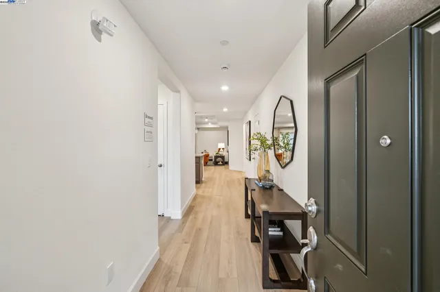 a view of a hallway with wooden floor and entryway