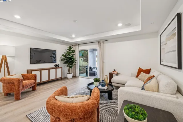 a living room with furniture a flat screen tv and a couch