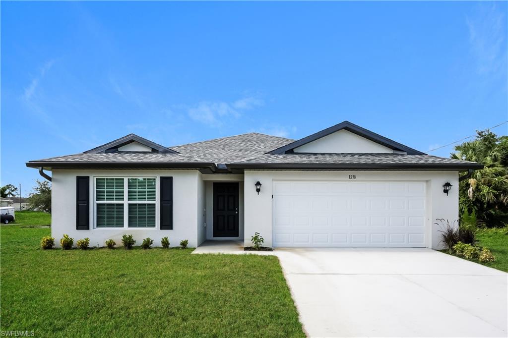 1218 Beaver Street East Lehigh Acres, FL 33974 - Photo 1 of 15 a front view of a house with a yard