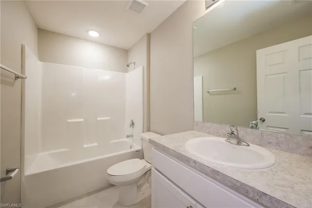 a bathroom with a sink a toilet and a large mirror
