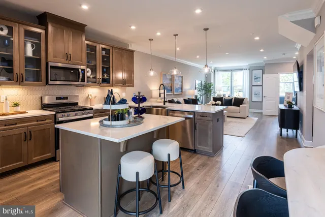 a kitchen with stainless steel appliances granite countertop a stove a sink dishwasher a dining table and chairs with wooden floor