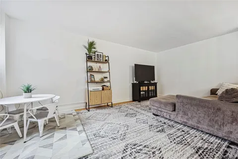 a living room with furniture a flat screen tv and a table