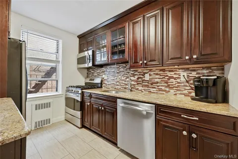 a kitchen with stainless steel appliances granite countertop a sink stove and microwave