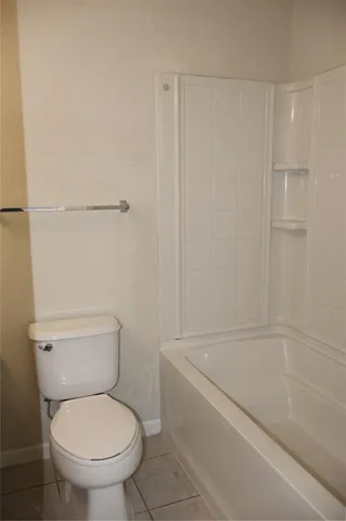 a white toilet sitting next to a bath tub