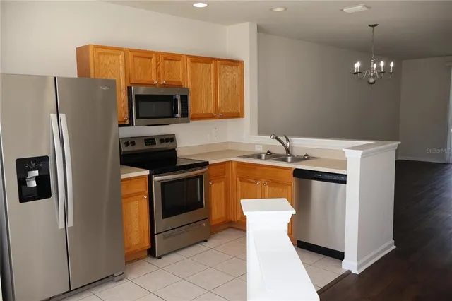 a kitchen with stainless steel appliances a refrigerator a stove a microwave oven a sink and dishwasher