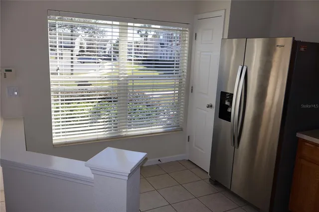 a view of a kitchen with a white cabinet and a refrigerator