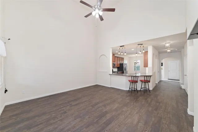 an empty room with wooden floor and a hallway