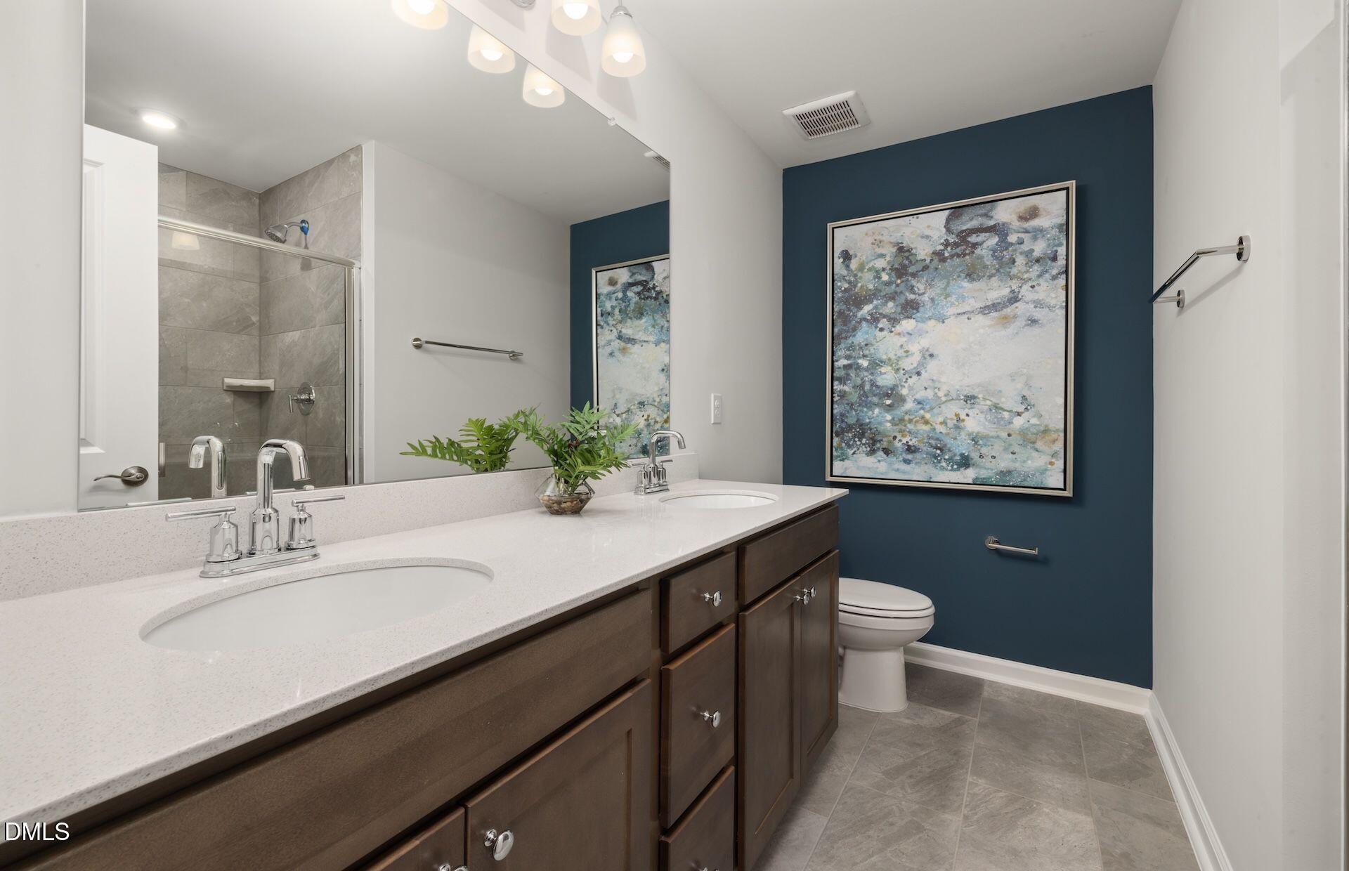 5003 Reader Way Durham, NC 27703 - Photo 11 of 30 a bathroom with a double vanity sink toilet and a mirror