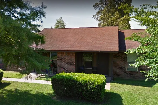 a view of a house with a yard and potted plants