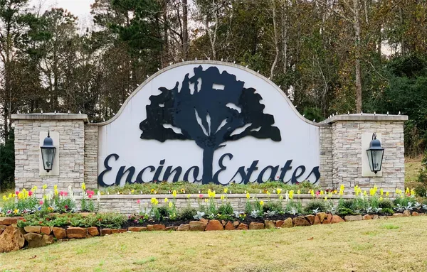 a front view of a building with garage and parking