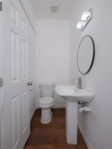 a bathroom with a toilet a sink and mirror