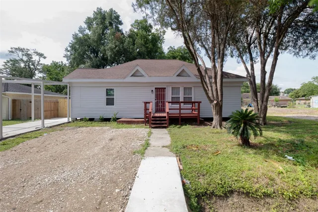a view of a house with backyard and tree