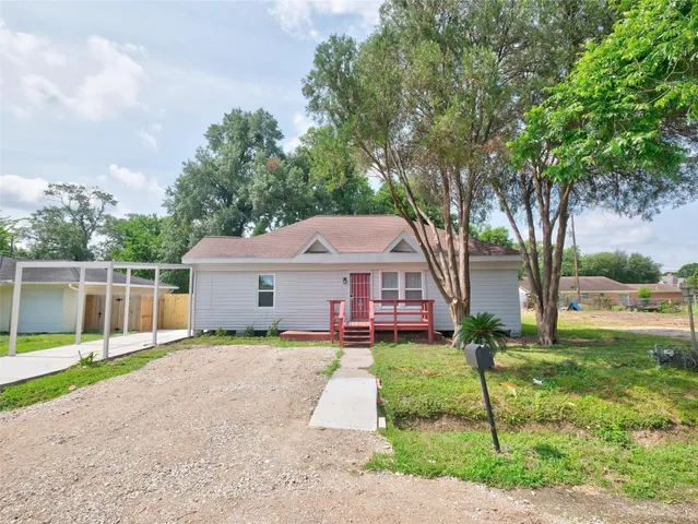 a view of a house with backyard and a tree
