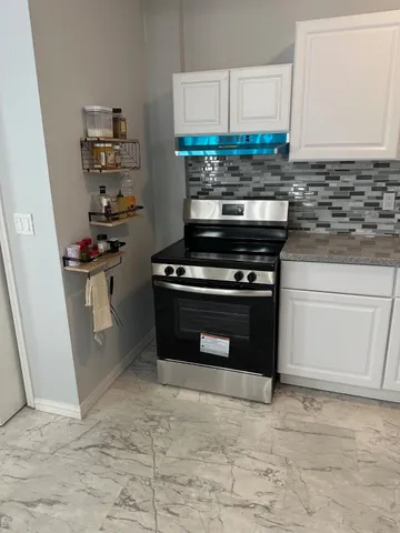 a kitchen with stainless steel appliances granite countertop a stove and a refrigerator