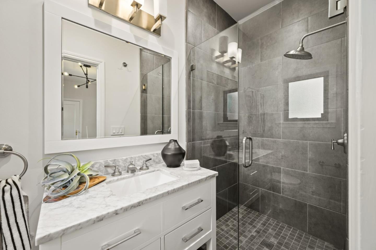 670 Edgewood Road San Mateo, CA 94402 - Photo 15 of 59 a bathroom with a granite countertop sink a mirror and a shower