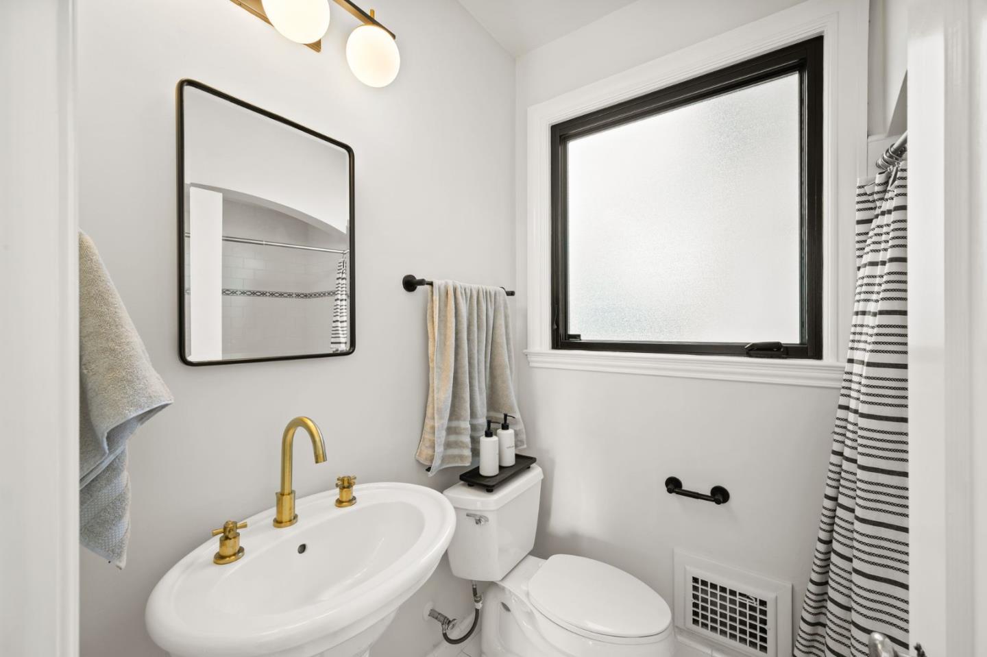 670 Edgewood Road San Mateo, CA 94402 - Photo 17 of 59 a bathroom with a sink mirror and toilet