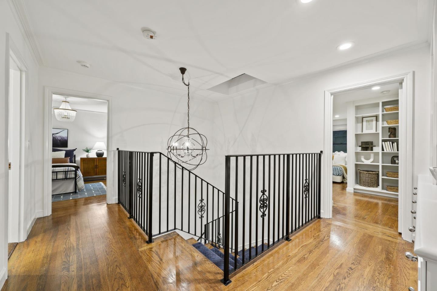 670 Edgewood Road San Mateo, CA 94402 - Photo 19 of 59 a view of a hallway with wooden floor and a chandelier