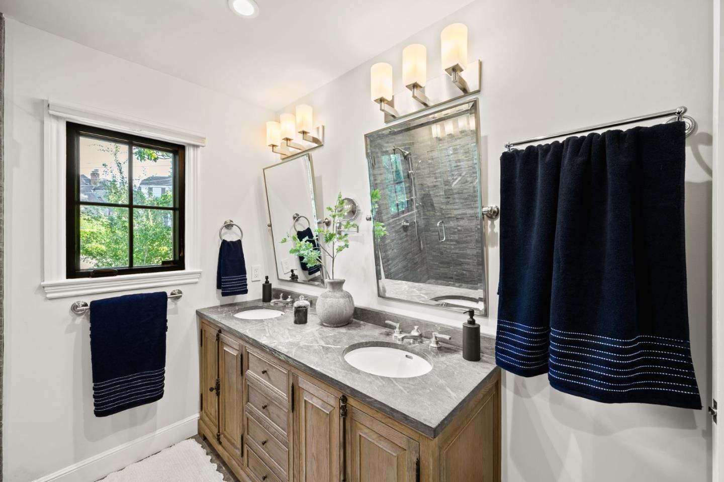 670 Edgewood Road San Mateo, CA 94402 - Photo 33 of 59 a bathroom with a sink a mirror and a shower