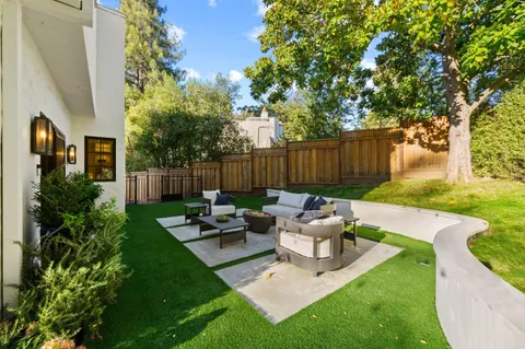 a view of a patio with couches potted plants and a big yard