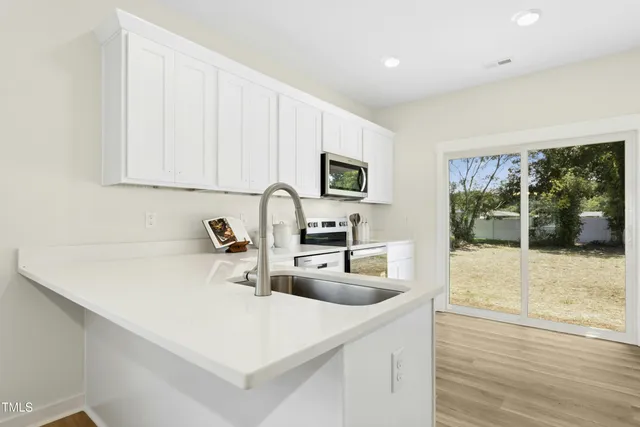 a kitchen with a sink a stove and a microwave oven
